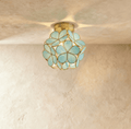 Golden teardrop cluster ceiling light fixture with warm amber glass on white ceiling in modern hallway.