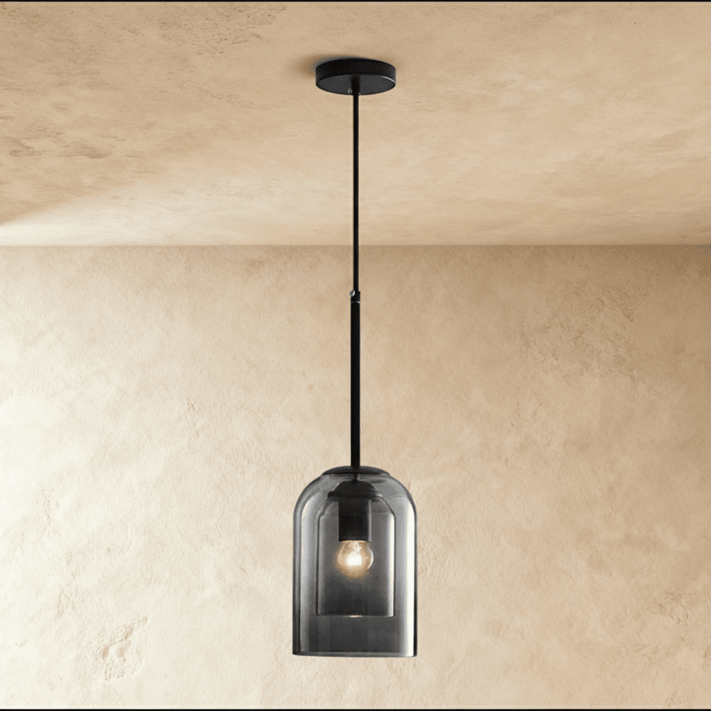 Clear glass pendant light with cylindrical shade, brushed metal hardware, suspended from ceiling canopy, white background, fr