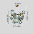 Modern chandelier with textured blue and white ribbons, brass accents, and warm interior lighting on gray background.