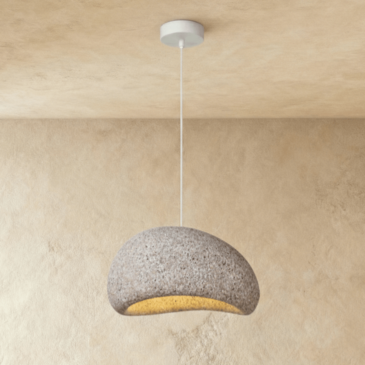 Three gray concrete dome pendant lights with warm interiors suspended above a cream sectional sofa in modern living room sett